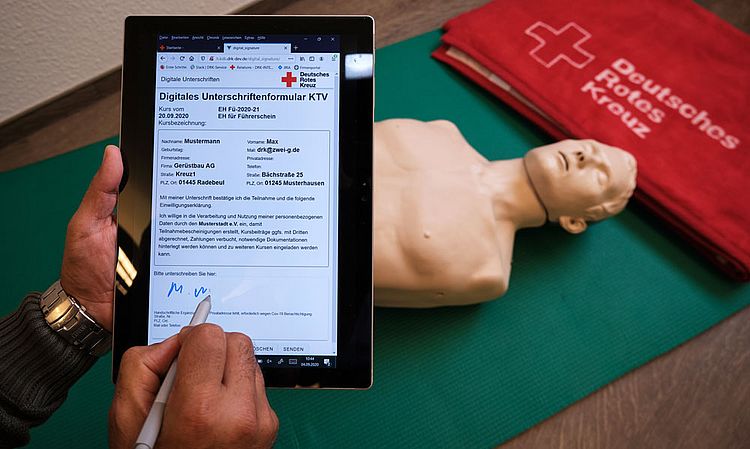 Das Imagebild zeigt ein Tablet, auf welchem ein Formular geöffnet ist, welches gerade via Touch unterzeichnet wird.