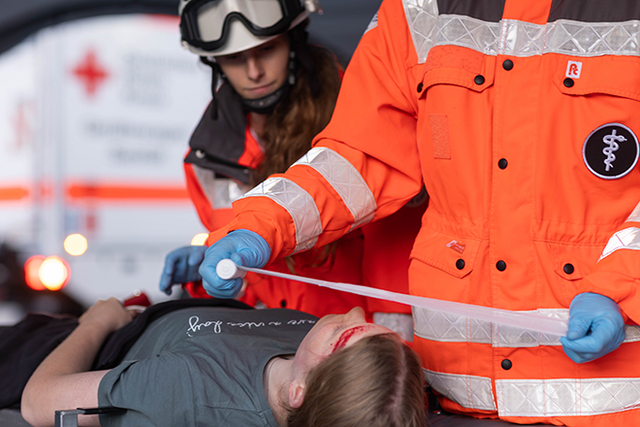 Dieses Imagebild zeigt zwei Sanitäter, die eine Person verbinden.